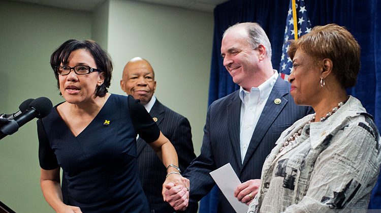 UNITED STATES - FEBRUARY 22: Karen Weaver, left, mayor of Flint, Mich., introduces Rep. Dan Kildee, D-Mich., during a news conference in Flint on the city's water crisis, February 22, 2016. The drinking water supply was not properly treated after being switched from Lake Huron to the Flint River and now contains lead and iron. Also appearing are, from left, Reps. Scott Peters, D-Calif., Elijah Cummings, D-Md., Brenda Lawrence, D-Mich., and Debbie Dingell, D-Mich. (Photo By Tom Williams/CQ Roll Call)